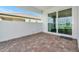 Cozy brick-paved patio area with sliding glass doors and views of the surrounding landscape at 17333 Savory Mist Cir, Bradenton, FL 34211