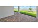 View of lake from the brick-paved, covered patio with white posts and bright green grass at 17333 Savory Mist Cir, Bradenton, FL 34211