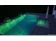 Beautifully lit modern swimming pool with green underwater lights, creating an enchanting ambiance for evening swims at 17333 Savory Mist Cir, Bradenton, FL 34211