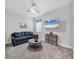 Bonus room with carpet, ceiling fan, a large television and a sofa at 17910 Waterville Pl, Lakewood Ranch, FL 34202