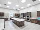 Large catering kitchen with stainless steel appliances, dark wood cabinets, and island at 17910 Waterville Pl, Lakewood Ranch, FL 34202