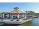 Elegant lakefront patio with dining tables, umbrellas, and views of the community pool and grounds at 17910 Waterville Pl, Lakewood Ranch, FL 34202