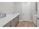 This laundry room has grey cabinets, white countertop, hardwood floors, and a utility sink at 17910 Waterville Pl, Lakewood Ranch, FL 34202