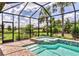 This screened in pool features an attached spa and beautiful landscaping at 17910 Waterville Pl, Lakewood Ranch, FL 34202