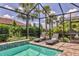 Screened-in pool area with a tanning ledge, lush landscaping, and comfortable lounge chairs at 17910 Waterville Pl, Lakewood Ranch, FL 34202