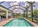 The screened in pool looks out over the lush landscaping and lake at 17910 Waterville Pl, Lakewood Ranch, FL 34202