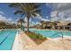 Beautiful community pool with sun loungers, palm trees, blue skies, and clubhouse at 17910 Waterville Pl, Lakewood Ranch, FL 34202