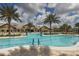 Community pool with sun loungers, palm trees, blue skies, and clubhouse at 17910 Waterville Pl, Lakewood Ranch, FL 34202