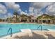 Stunning community pool with sun loungers, palm trees, blue skies, and clubhouse at 17910 Waterville Pl, Lakewood Ranch, FL 34202