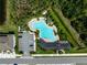 Overhead shot of community pool with a freeform shape surrounded by lots of green and parking at 2136 Midnight Pearl Dr, Sarasota, FL 34240