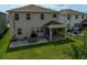 A spacious backyard with a covered patio, lush lawn, and ample space for outdoor activities and entertaining at 2136 Midnight Pearl Dr, Sarasota, FL 34240