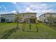 Fenced backyard with a swing set and seating area, perfect for outdoor fun and relaxation at 2136 Midnight Pearl Dr, Sarasota, FL 34240