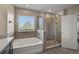 Well-lit bathroom with separate tub and glass enclosed shower, enhanced with natural light through a large window at 2136 Midnight Pearl Dr, Sarasota, FL 34240