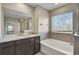Bright bathroom featuring a double vanity, bathtub, and a glass shower at 2136 Midnight Pearl Dr, Sarasota, FL 34240