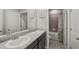 Bathroom featuring a double vanity with white sinks, dark wood cabinets, and a shower with a tub at 2136 Midnight Pearl Dr, Sarasota, FL 34240