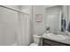 Clean bathroom featuring a shower with white tile, a granite countertop sink, and a framed wall art at 2136 Midnight Pearl Dr, Sarasota, FL 34240