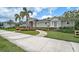 Inviting clubhouse entrance with brick walkway, lush landscaping and exterior architectural details at 2136 Midnight Pearl Dr, Sarasota, FL 34240