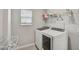 Functional laundry room equipped with a window, washer, dryer, and storage shelving for cleaning supplies at 2136 Midnight Pearl Dr, Sarasota, FL 34240