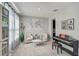 Bright living room with carpet, two chairs, a table, and a piano, complemented by a world map and curtains at 2136 Midnight Pearl Dr, Sarasota, FL 34240