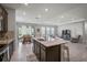 Open-concept kitchen and living space with dark cabinets, a granite island, and tile floors at 2136 Midnight Pearl Dr, Sarasota, FL 34240