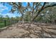 Community playground featuring mature trees, a secure fence, and play equipment at 2136 Midnight Pearl Dr, Sarasota, FL 34240