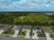 A neighborhood street showcasing well-maintained homes, green lawns, and lush landscaping with a green field in the background at 2136 Midnight Pearl Dr, Sarasota, FL 34240