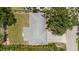 Birds eye view of a single story home with a gray roof, mature trees, fenced in yard and long driveway at 2275 Clematis St, Sarasota, FL 34239