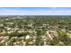 An aerial view captures the neighborhood featuring lush tree coverage, well maintained homes, and clear blue skies in the distance at 2275 Clematis St, Sarasota, FL 34239