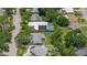 An overhead view of the home and neighborhood shows a solar panel array, in-ground pool, mature trees, and well-maintained lawns at 2275 Clematis St, Sarasota, FL 34239