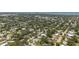 An aerial view captures the neighborhood with lush tree coverage and well-maintained homes under the bright blue sky at 2275 Clematis St, Sarasota, FL 34239