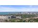 This aerial view features the city skyline and bay waters in the distance over a neighborhood with lush tree coverage at 2275 Clematis St, Sarasota, FL 34239