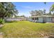 Spacious backyard featuring a well-manicured lawn, partial fence, and lovely exterior home with two chairs on the patio at 2275 Clematis St, Sarasota, FL 34239