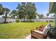 Relaxing backyard featuring a well-manicured lawn, partial fence, shady oak tree, and lovely patio furniture at 2275 Clematis St, Sarasota, FL 34239