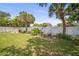 Relaxing backyard featuring a well-manicured lawn, white fence, lovely flowers, and tropical palm trees at 2275 Clematis St, Sarasota, FL 34239