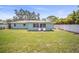 Beautiful backyard featuring a well-manicured lawn, privacy fence, and lovely exterior home with two chairs on the patio at 2275 Clematis St, Sarasota, FL 34239