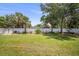 Beautiful backyard featuring a well-manicured lawn, white fence, lovely flowers, tropical palm trees, and storage shed at 2275 Clematis St, Sarasota, FL 34239