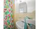 Cozy bathroom featuring yellow tiling, a sink, and colorful shower curtain at 2275 Clematis St, Sarasota, FL 34239