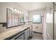 Vintage bathroom featuring tiled vanity, shower with pink curtain, and window at 2275 Clematis St, Sarasota, FL 34239