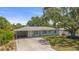 Charming single-story home with a long driveway, mature trees, partial fence, and a lovely exterior at 2275 Clematis St, Sarasota, FL 34239