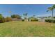 Expansive backyard with lush grass, privacy fencing, and mature trees, offering a serene outdoor space at 320 59Th W St, Bradenton, FL 34209