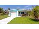 Charming home with a well-manicured lawn, bright turquoise trim, and a paved driveway at 320 59Th W St, Bradenton, FL 34209