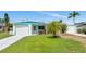 Charming single-story home with a well-maintained lawn, an attached garage, and beautiful turquoise trim at 320 59Th W St, Bradenton, FL 34209