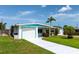 Charming single-story home with a well-maintained lawn, an attached garage, and beautiful turquoise trim at 320 59Th W St, Bradenton, FL 34209