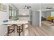Kitchen with tiled breakfast bar, white cabinetry, modern appliances, and light wood-look flooring at 320 59Th W St, Bradenton, FL 34209