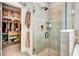 Stylish bathroom with a walk-in shower featuring gray tiling, and an adjacent, fully organized walk-in closet at 3218 Big Sky Way, Bradenton, FL 34211