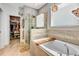 Elegant bathroom featuring a soaking tub, glass shower, and an organized walk-in closet at 3218 Big Sky Way, Bradenton, FL 34211