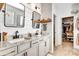 Modern bathroom with double vanity, granite counters, shiplap wall, and walk-in closet at 3218 Big Sky Way, Bradenton, FL 34211
