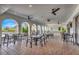 Spacious, covered outdoor seating area with arched openings, ceiling fans, and views of lush landscaping at 3218 Big Sky Way, Bradenton, FL 34211