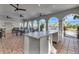 Covered outdoor bar and seating area with ceiling fans and views of lush landscaping at 3218 Big Sky Way, Bradenton, FL 34211