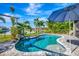 Beautiful pool area with lush tropical landscaping, a waterfall feature, and a lake view at 3218 Big Sky Way, Bradenton, FL 34211